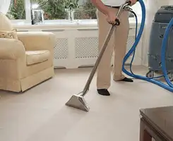 Carpet cleaning professional removing dirt and stains with a hot-water extraction tool in a home, Tacoma, WA.